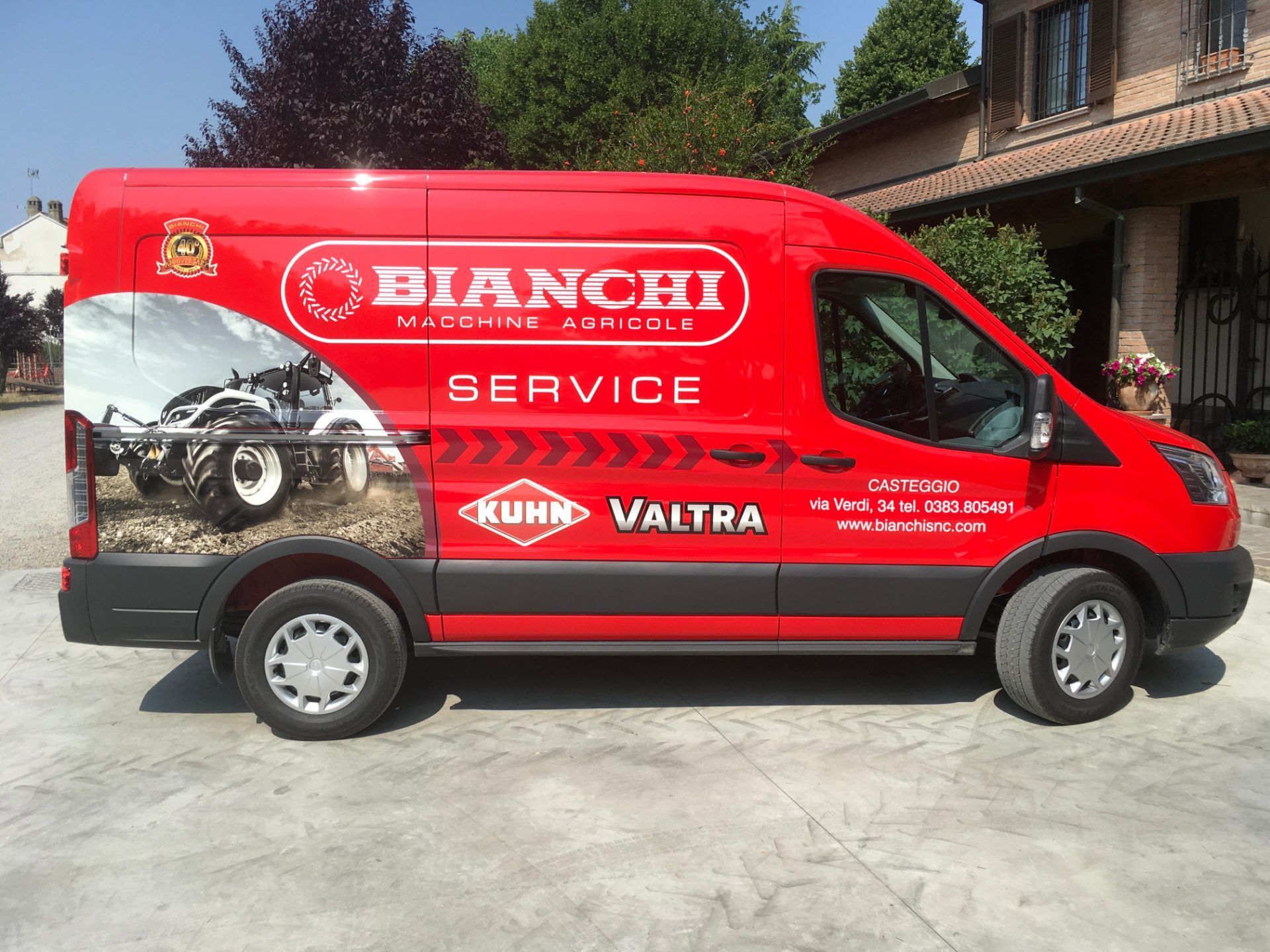 Un furgone di servizio Bianchi rosso è parcheggiato davanti a un edificio