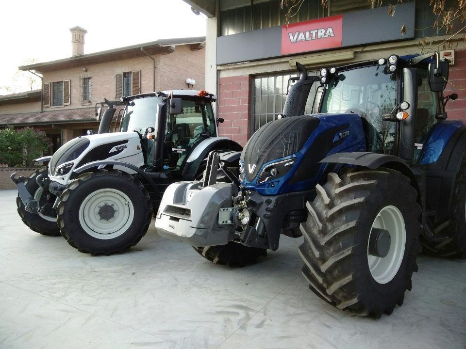 Tre trattori valtra sono parcheggiati davanti a un edificio