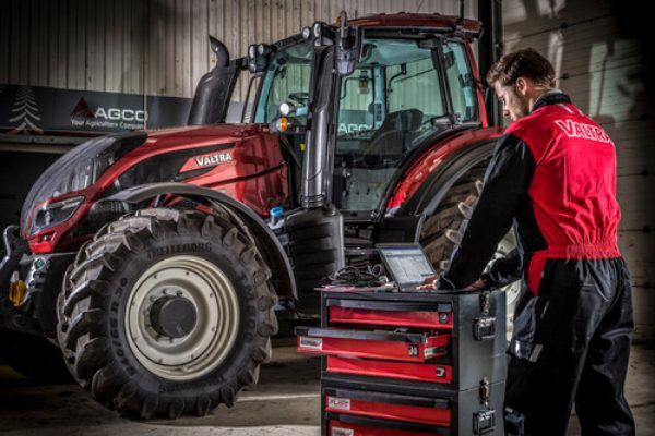 Un uomo sta lavorando su un trattore in un garage.