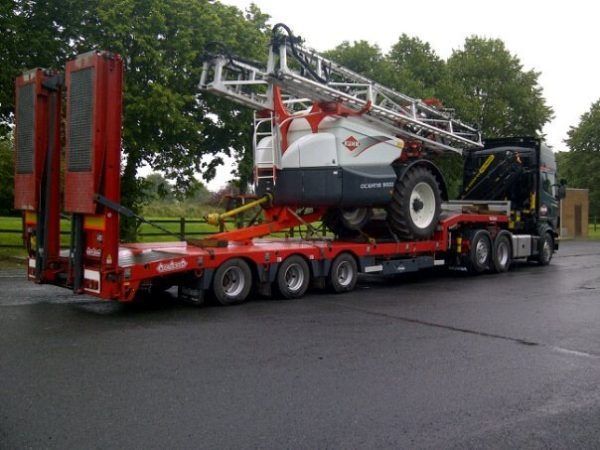 Un camion con un trattore sul retro
