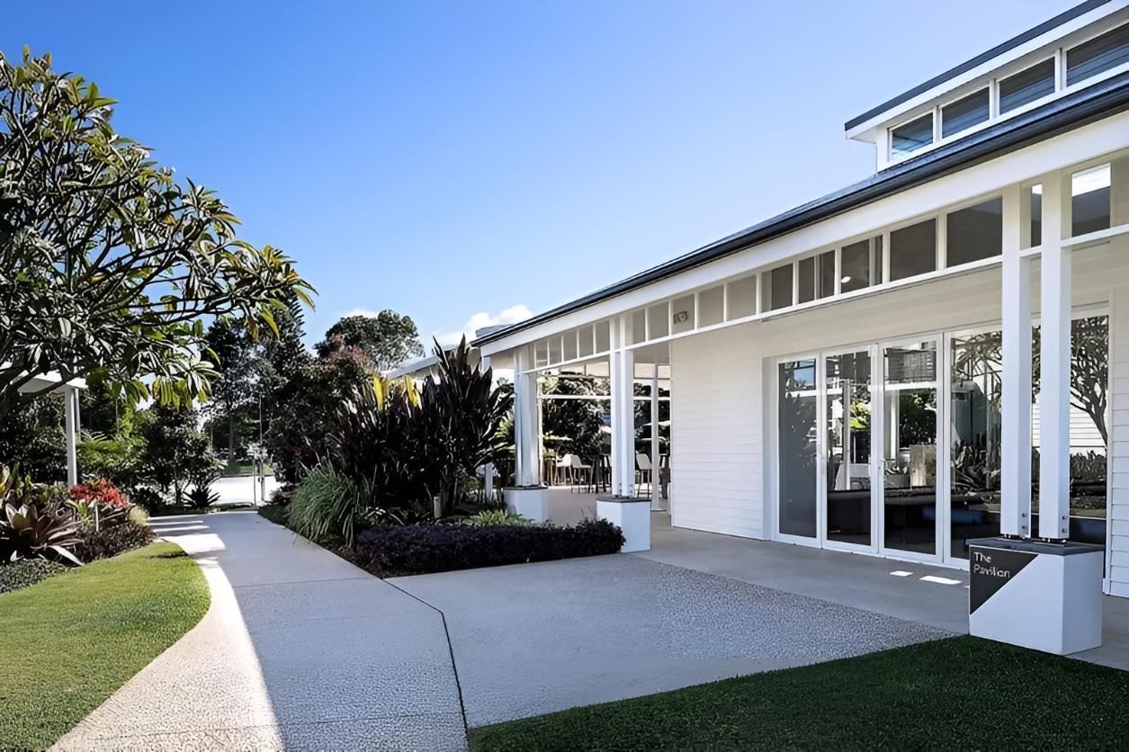 A Large White Building With a Walkway Leading to It — Aspex Construction - Lou Pieren In Port Macquarie, NSW