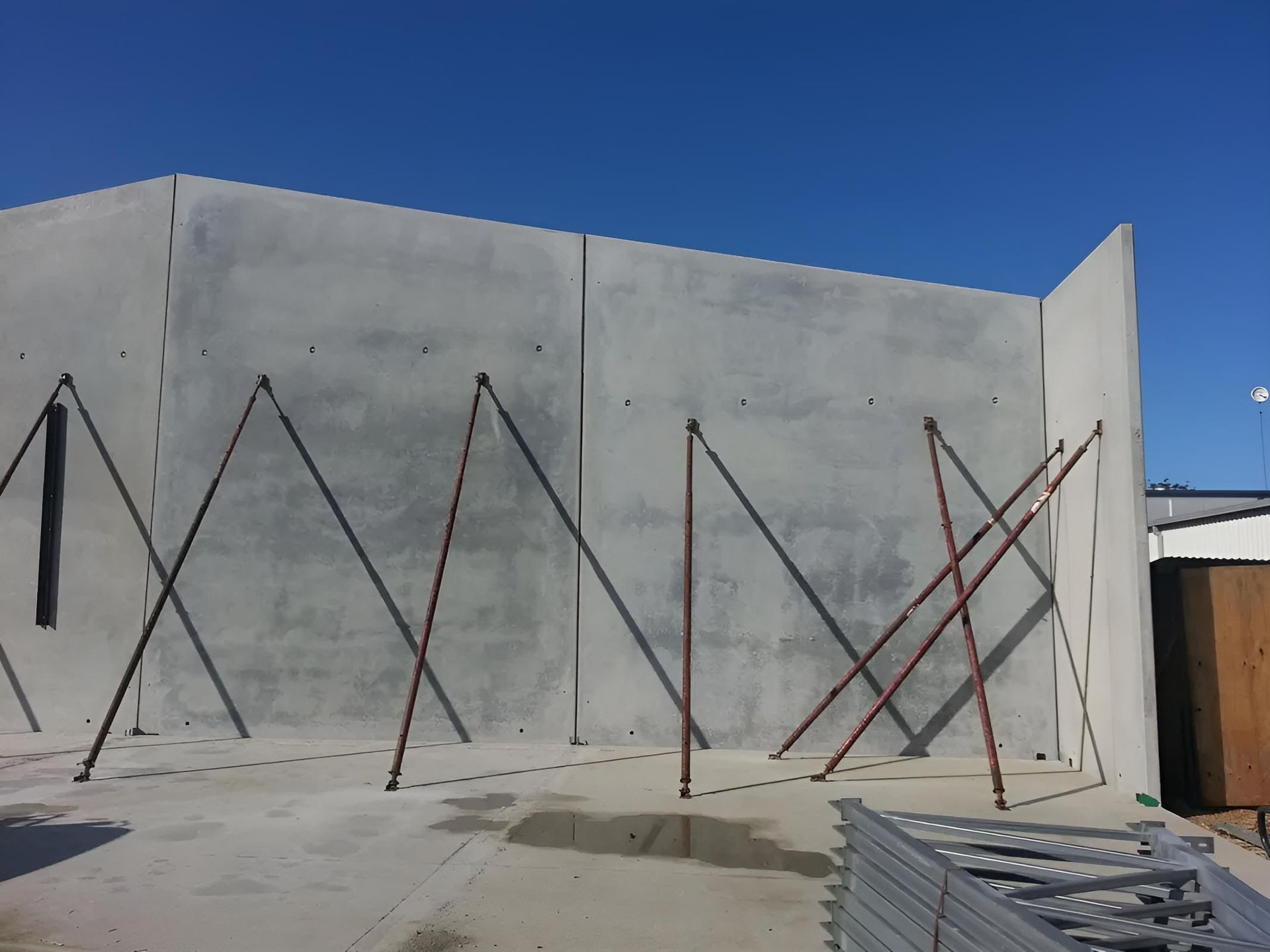 A Concrete Wall With Scaffolding on It — Aspex Construction - Lou Pieren In Port Macquarie, NSW