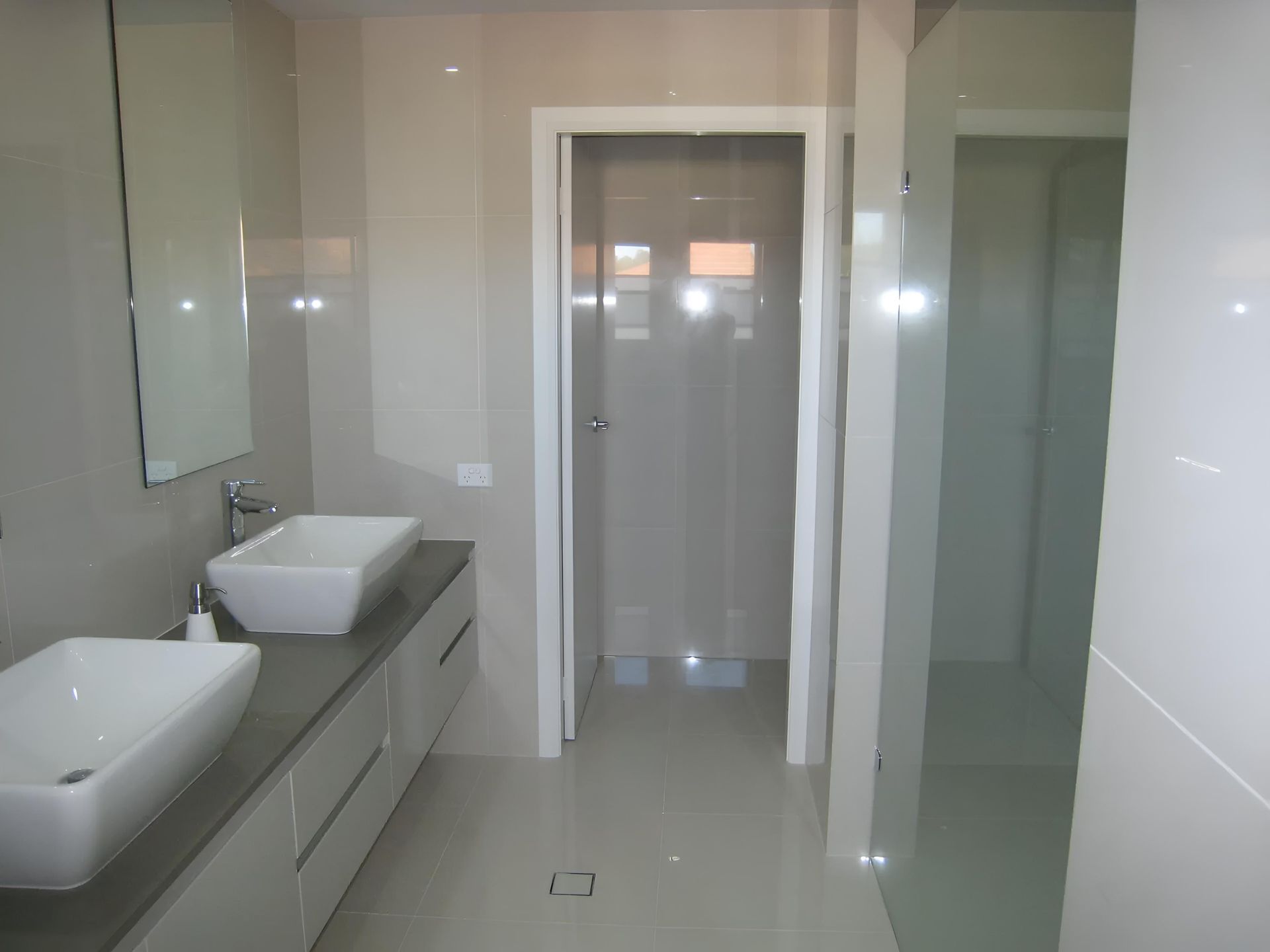 A Bathroom With Two Sinks and a Mirror — Aspex Construction - Lou Pieren In Port Macquarie, NSW