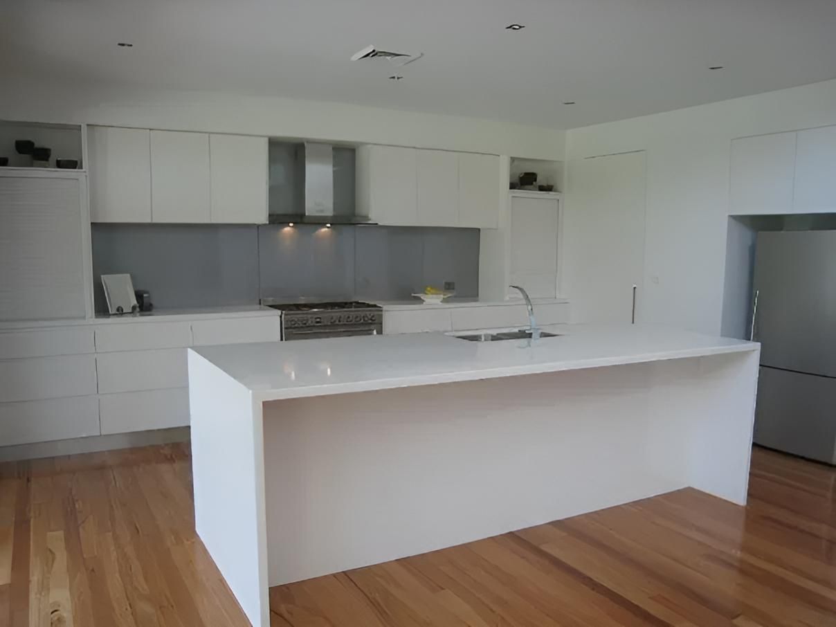 A Kitchen With White Cabinets and a Large White Island — Aspex Construction - Lou Pieren In Port Macquarie, NSW