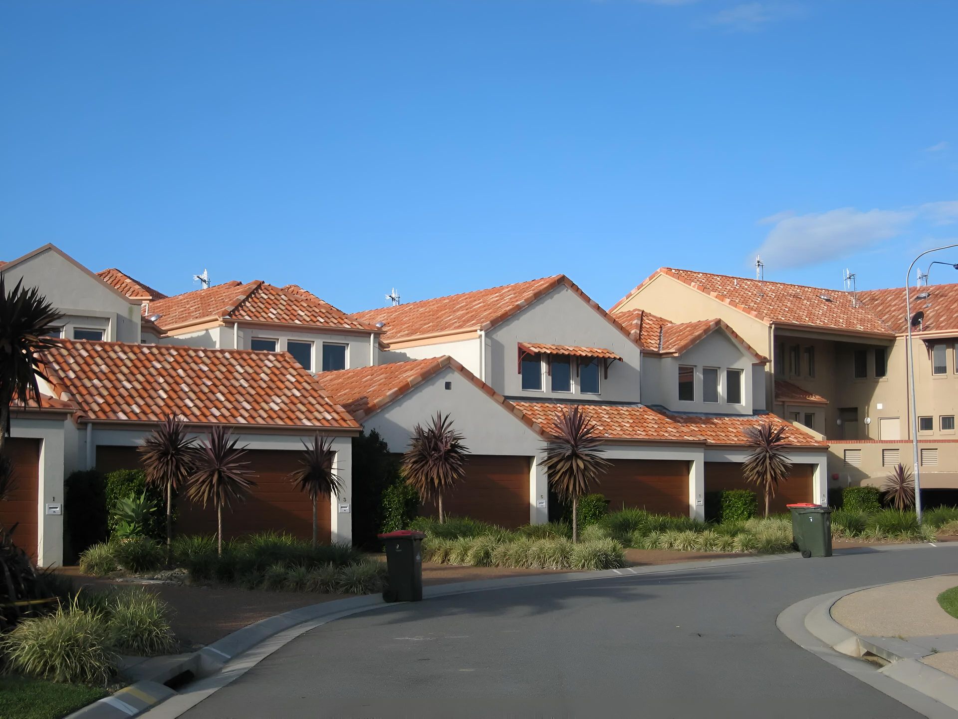 A Row of Houses With Red Tile Roofs — Aspex Construction - Lou Pieren In Bonny Hills, NSW