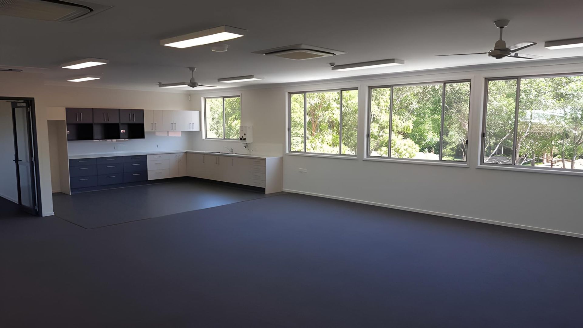 An Empty Room With a Lot of Windows and a Ceiling Fan — Aspex Construction - Lou Pieren In Port Macquarie, NSW