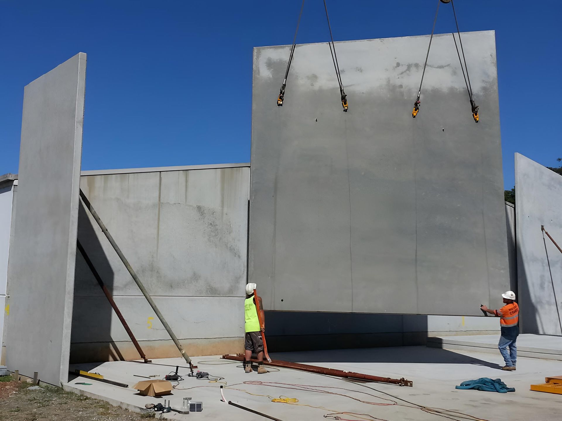 Two Construction Workers Are Working on a Large Concrete Wall — Aspex Construction - Lou Pieren In Bonny Hills, NSW