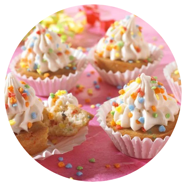 Cupcakes with frosting and sprinkles on a pink surface