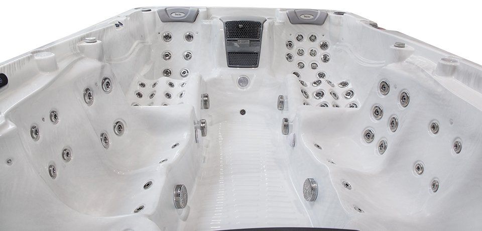 Interior of a white hot tub with multiple jets, angled view.