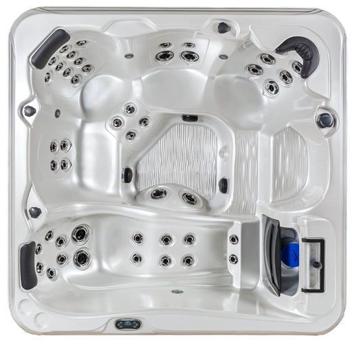 A top-down view of a white, square hot tub with multiple molded seats, headrests, and integrated water jets.