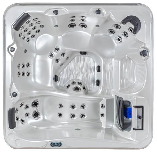 Top-down view of a light-colored, rectangular hot tub with multiple contoured seats, headrests, and integrated jet nozzles.