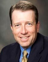 A man in a suit and tie is smiling for the camera.