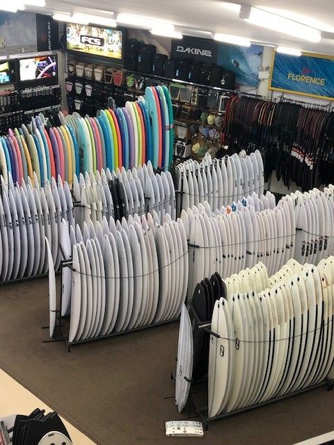 A Bunch of Surfboards Are Lined up In a Store — Slimes Boardstore in Erina, NSW