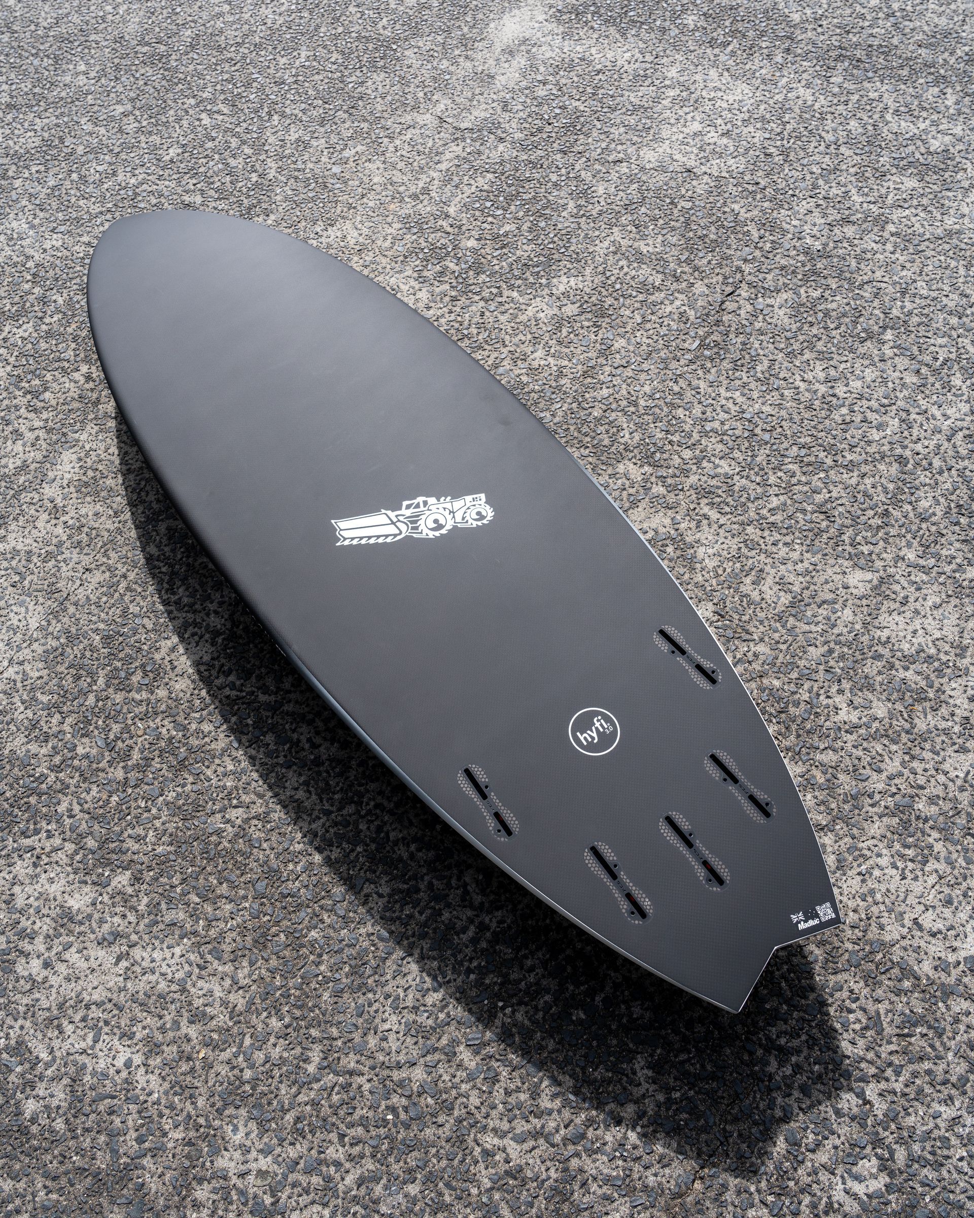 A Black Surfboard is Sitting on a Concrete Surface — Slimes Boardstore in Erina, NSW