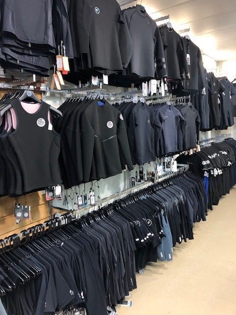 Wetsuits Hanging Up in the Surf Shop — Surf Shop in Erina, NSW