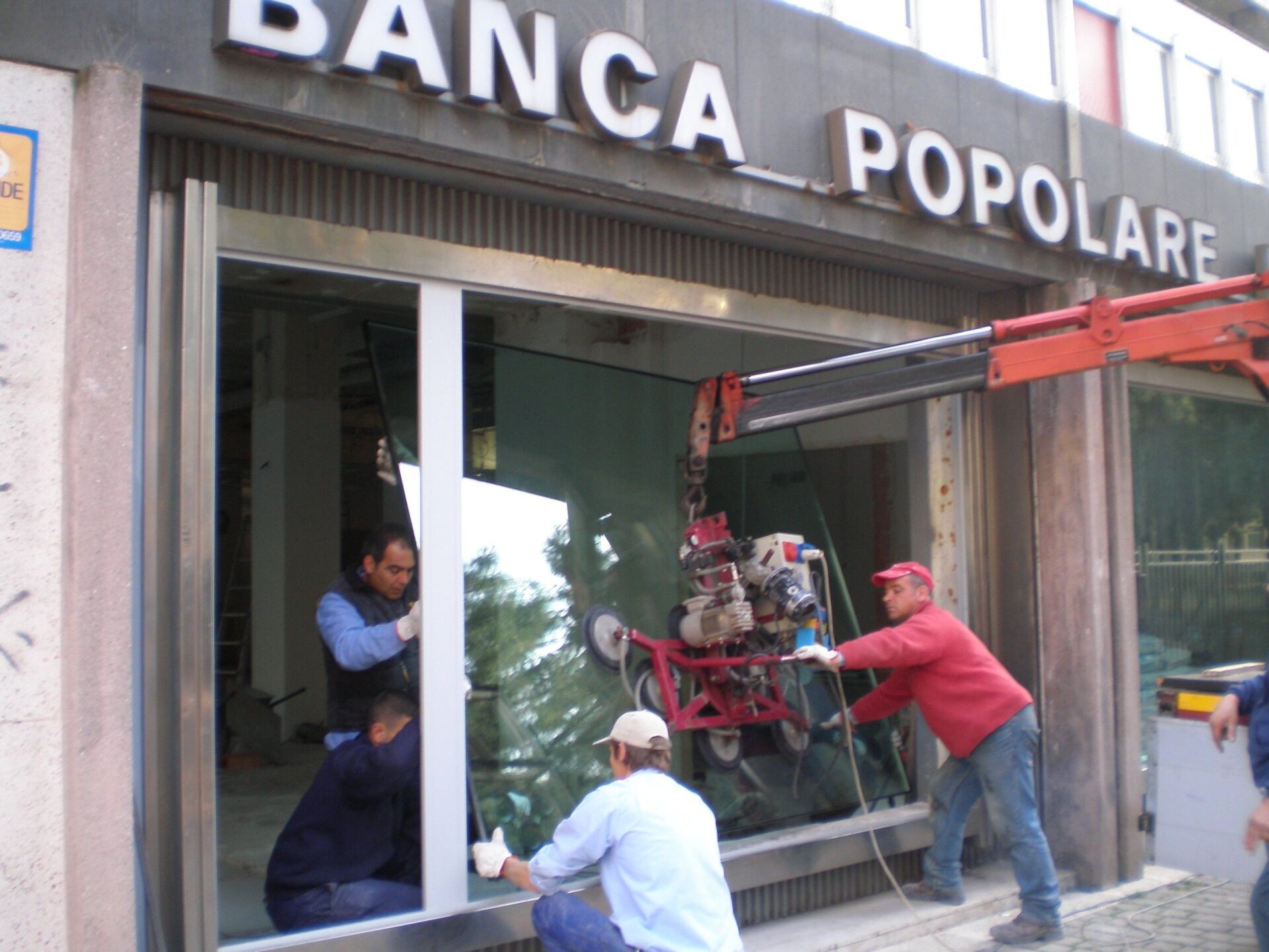 operai durante la posa di un vetro in una banca