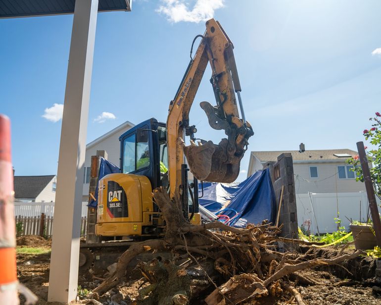 A cat excavator is digging a hole in the ground