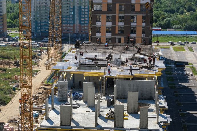 An aerial view of a building under construction in a city.