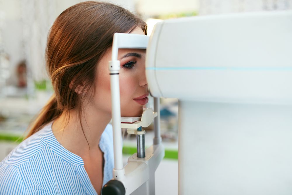 A Woman Is Getting Her Eyes Checked by An Ophthalmologist — John Williams Optometrist in Grafton, NSW