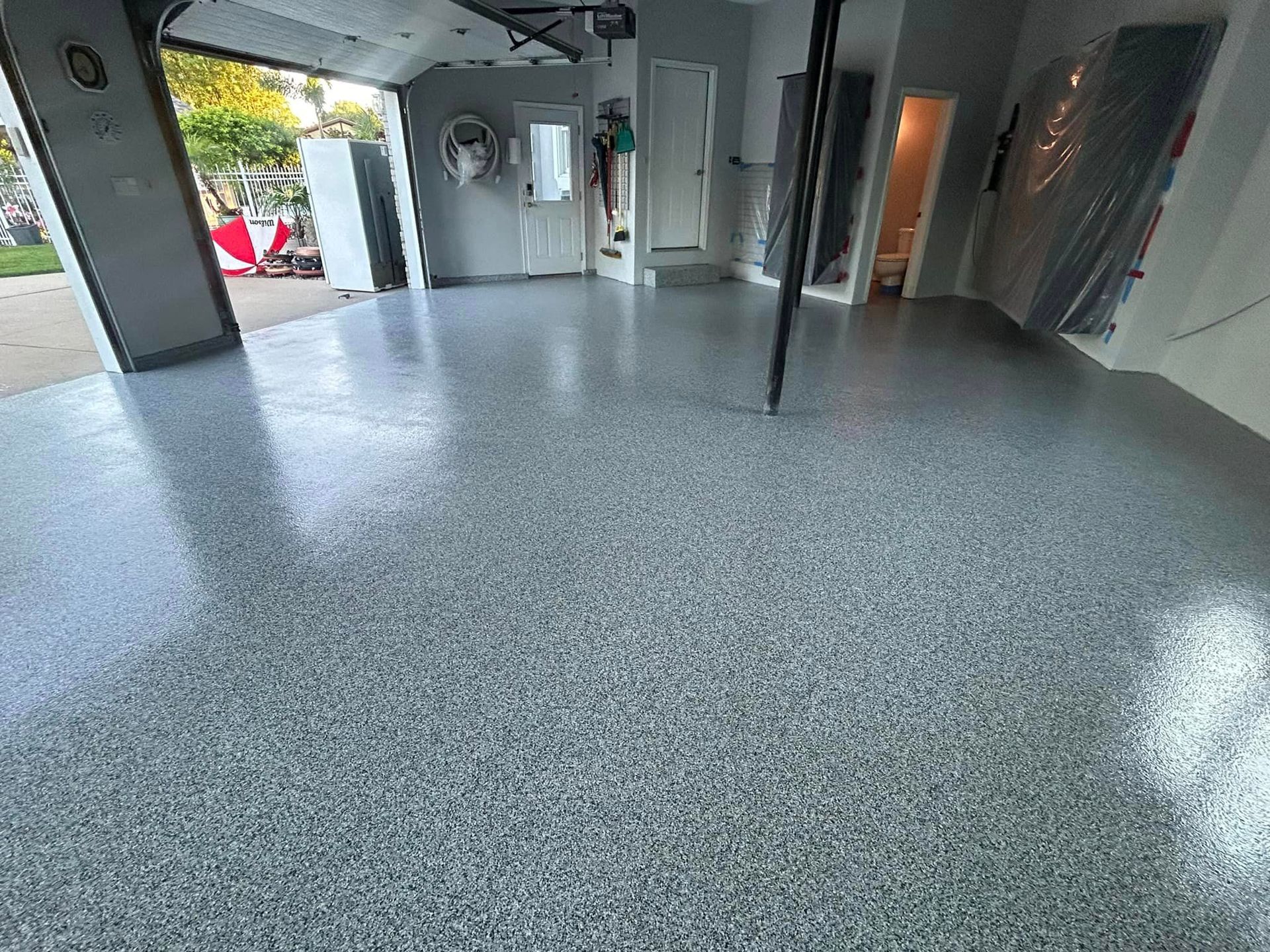 A garage with a gray floor and a garage door.