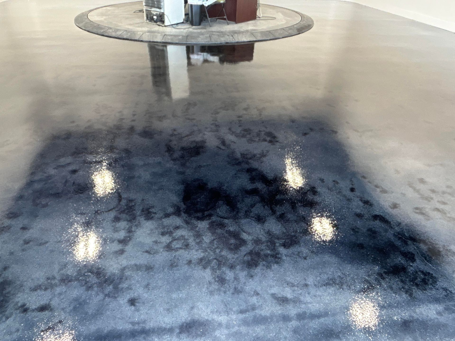 A table is sitting on top of a shiny concrete floor.