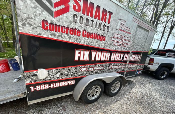 A trailer for smart coatings concrete coatings is parked next to a truck.