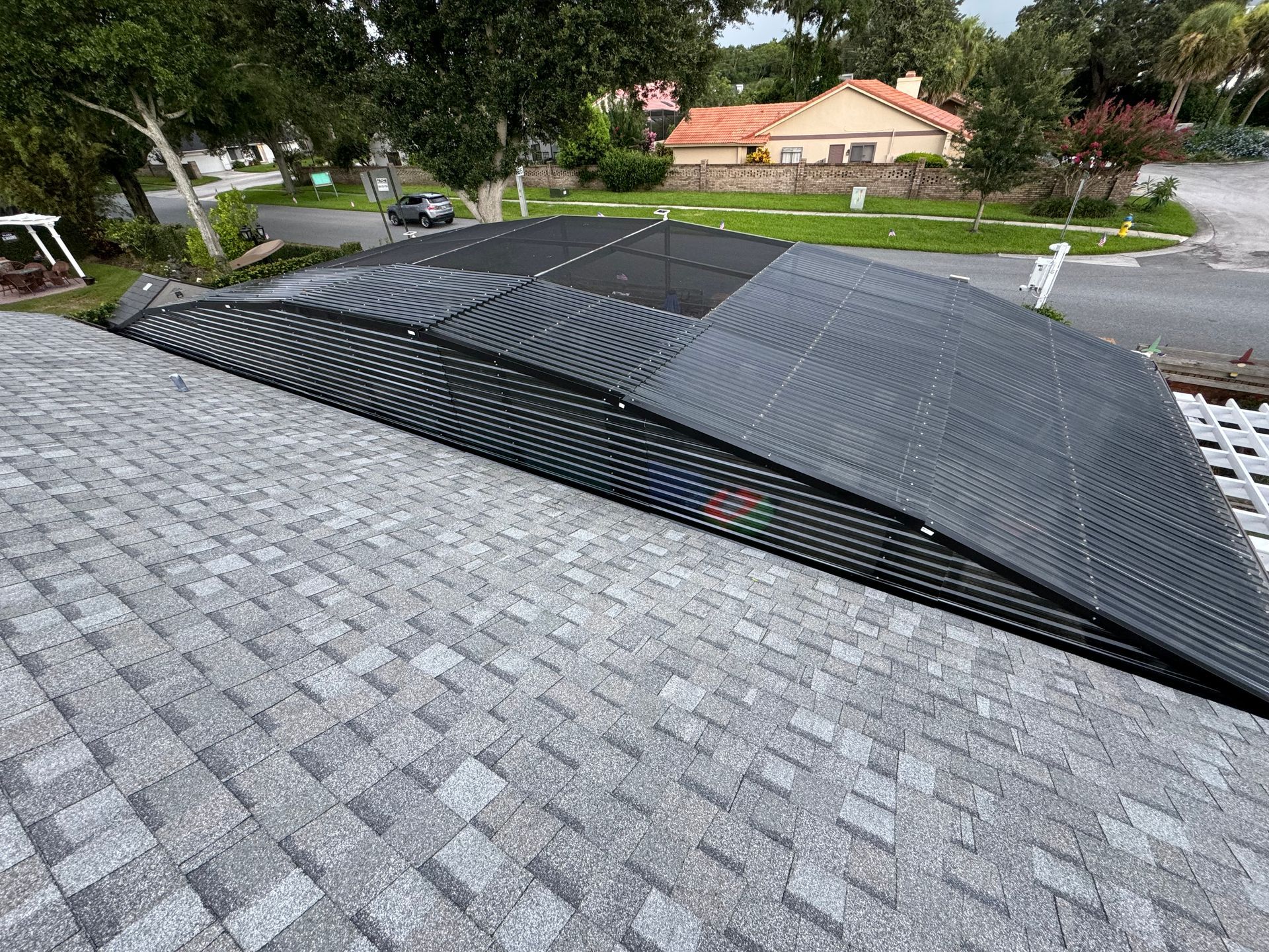 Solar pool heating panels installed on a residential gray asphalt shingle roof.