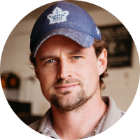 A man wearing a blue hat with a maple leaf on it