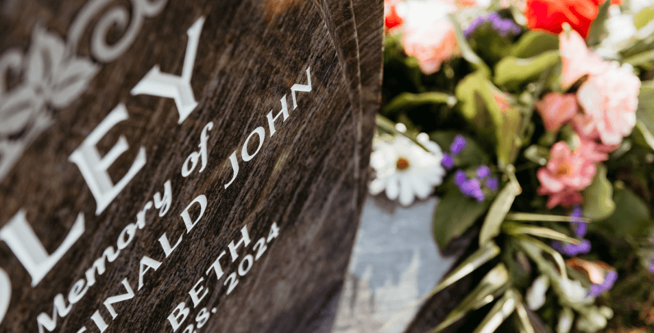 A close up of a gravestone with flowers in front of it.
