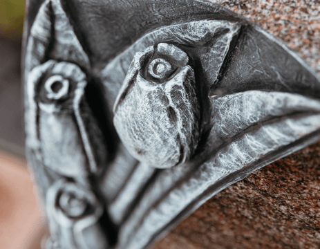 A close up of a sculpture of a bird on a rock.