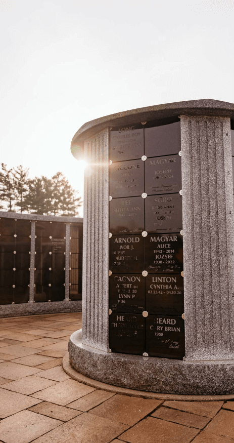The sun is shining through the columns of a cemetery.
