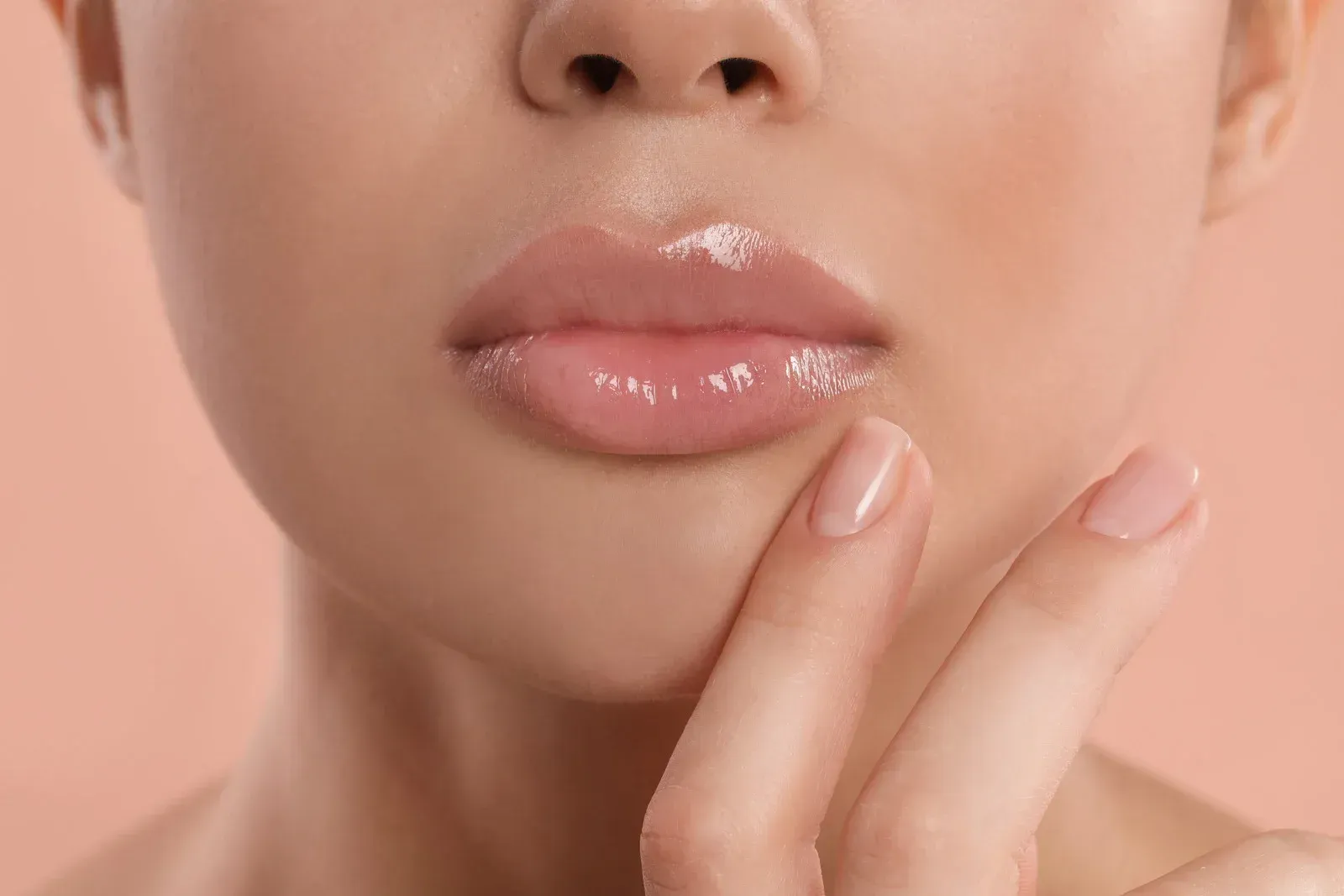 A woman is getting a botox injection in her lips.