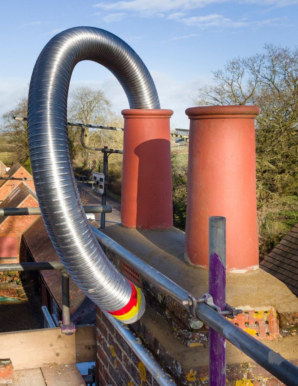 A chimney with a metal hose attached to it