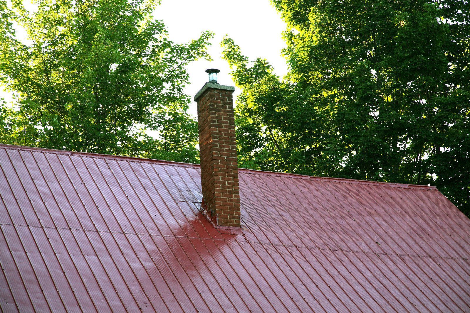 A red roof with a chimney on top of it