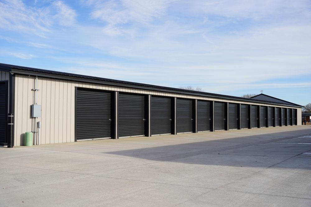 Storage Units in A Row, with Black Doors and Beige Siding, Under a Blue Sky — Nelson Bay Self Storage in Salamander Bay, NSW