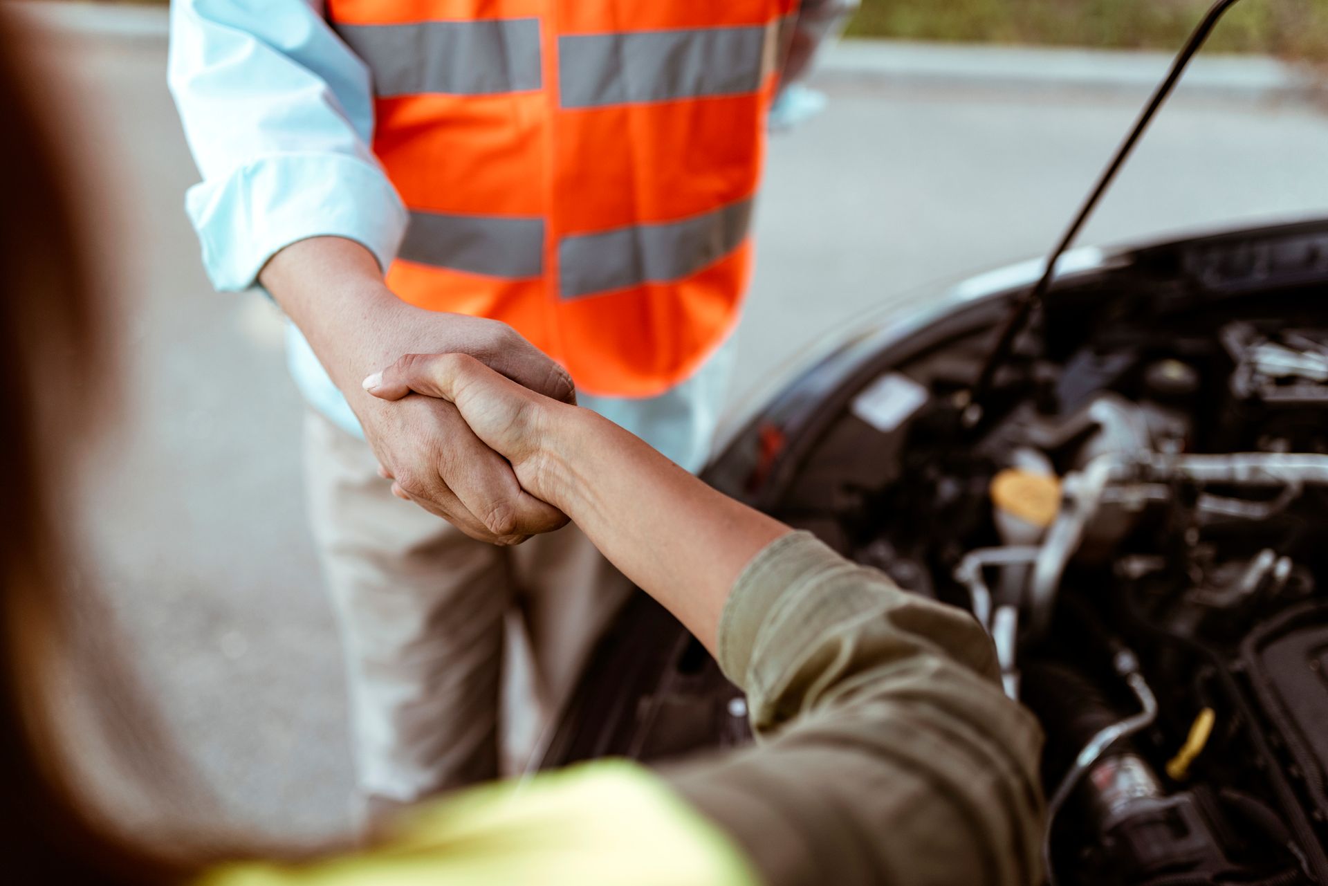 Woman thanking and shaking hands with mechanic from Parkway Wrecker Service for fast roadside assistance in Tallahassee, Fl.