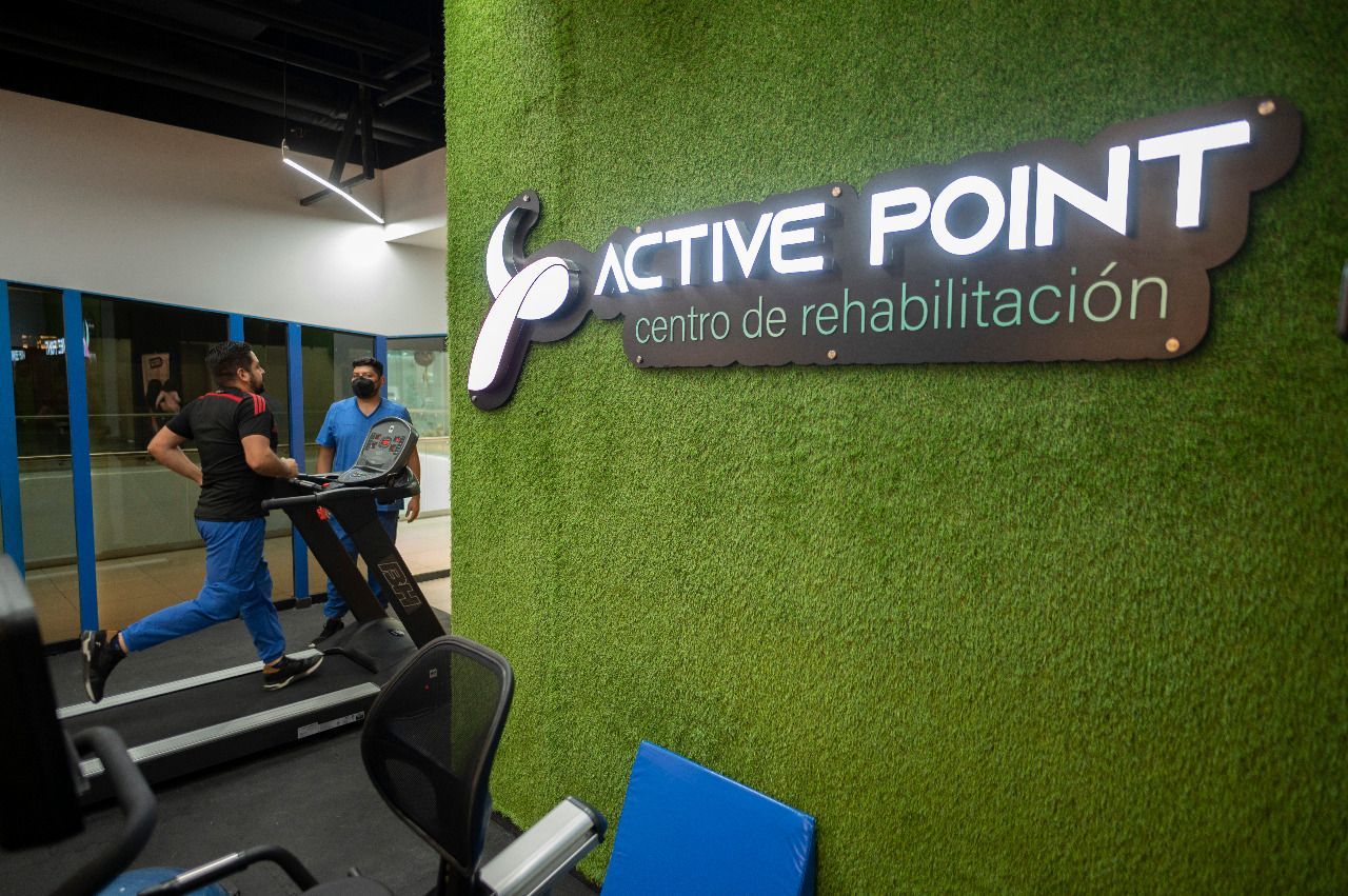 Hands massaging a leg covered by a blue cloth; person lying down.