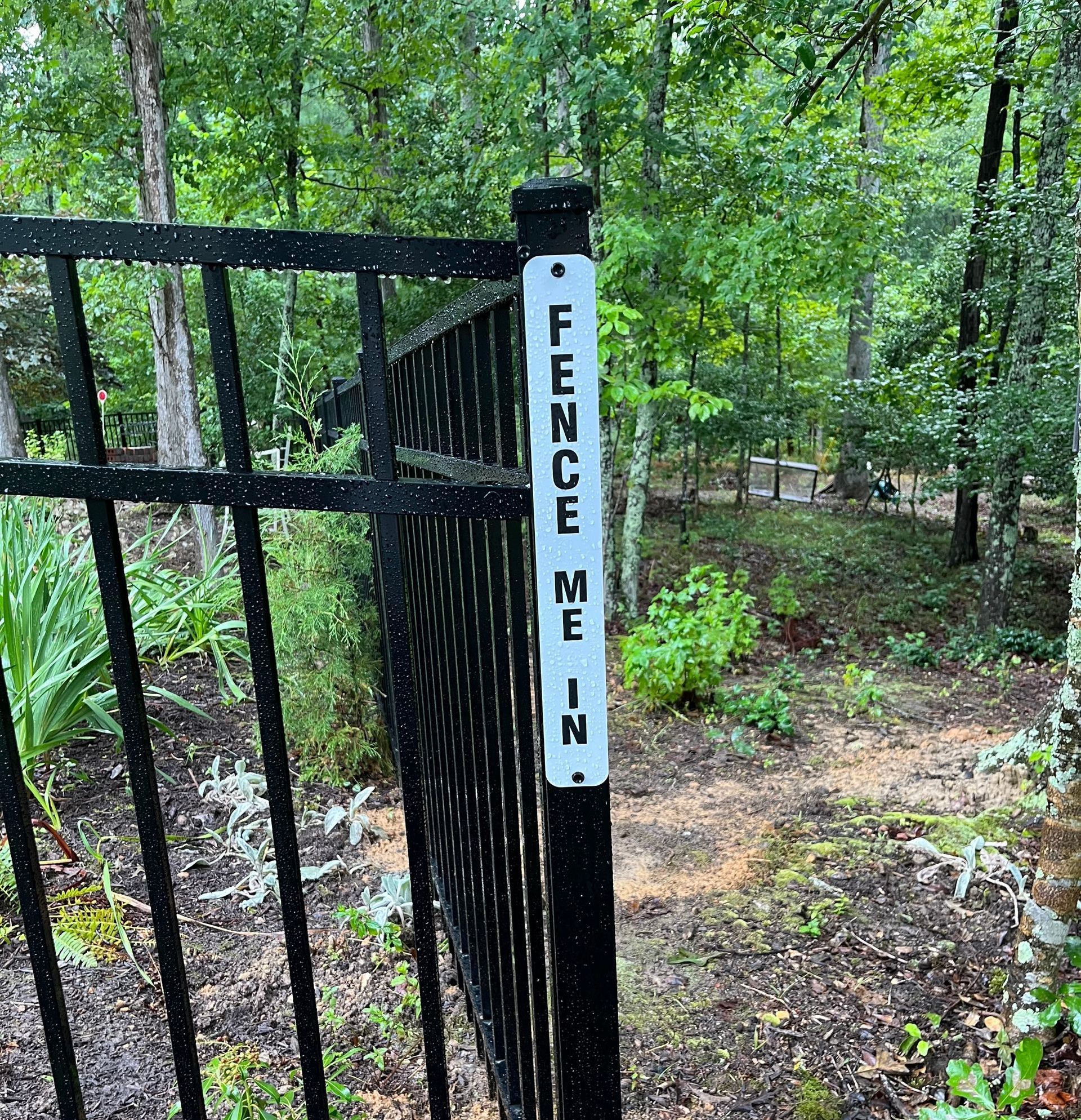 Black metal fence with a sign that reads 