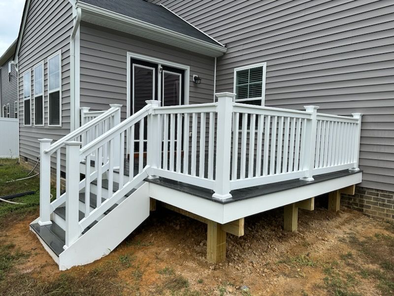 White deck with stairs, railings, and composite decking against a gray house.