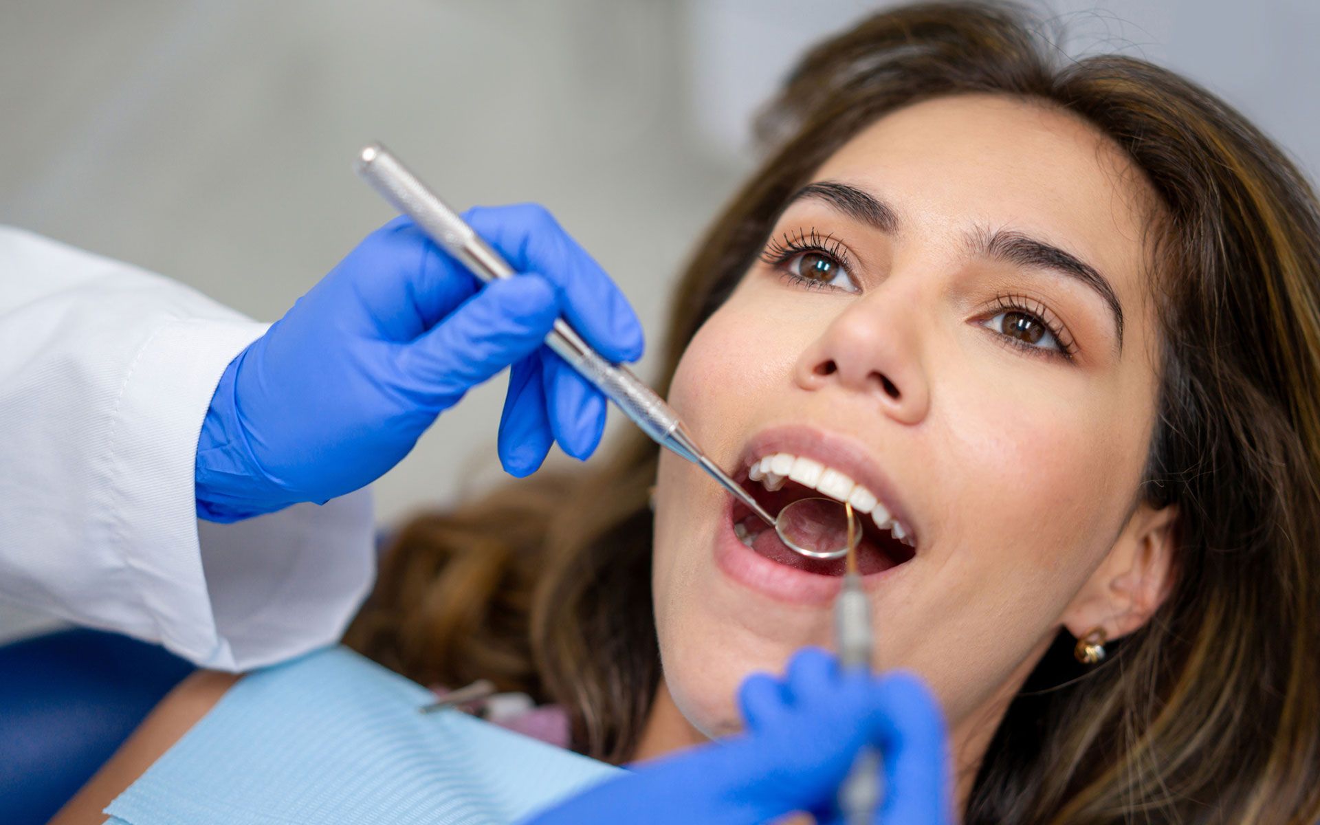 A dentist and a patient are looking at an x-ray in a dental office.