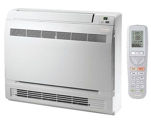 A white air conditioner with a remote control next to it.