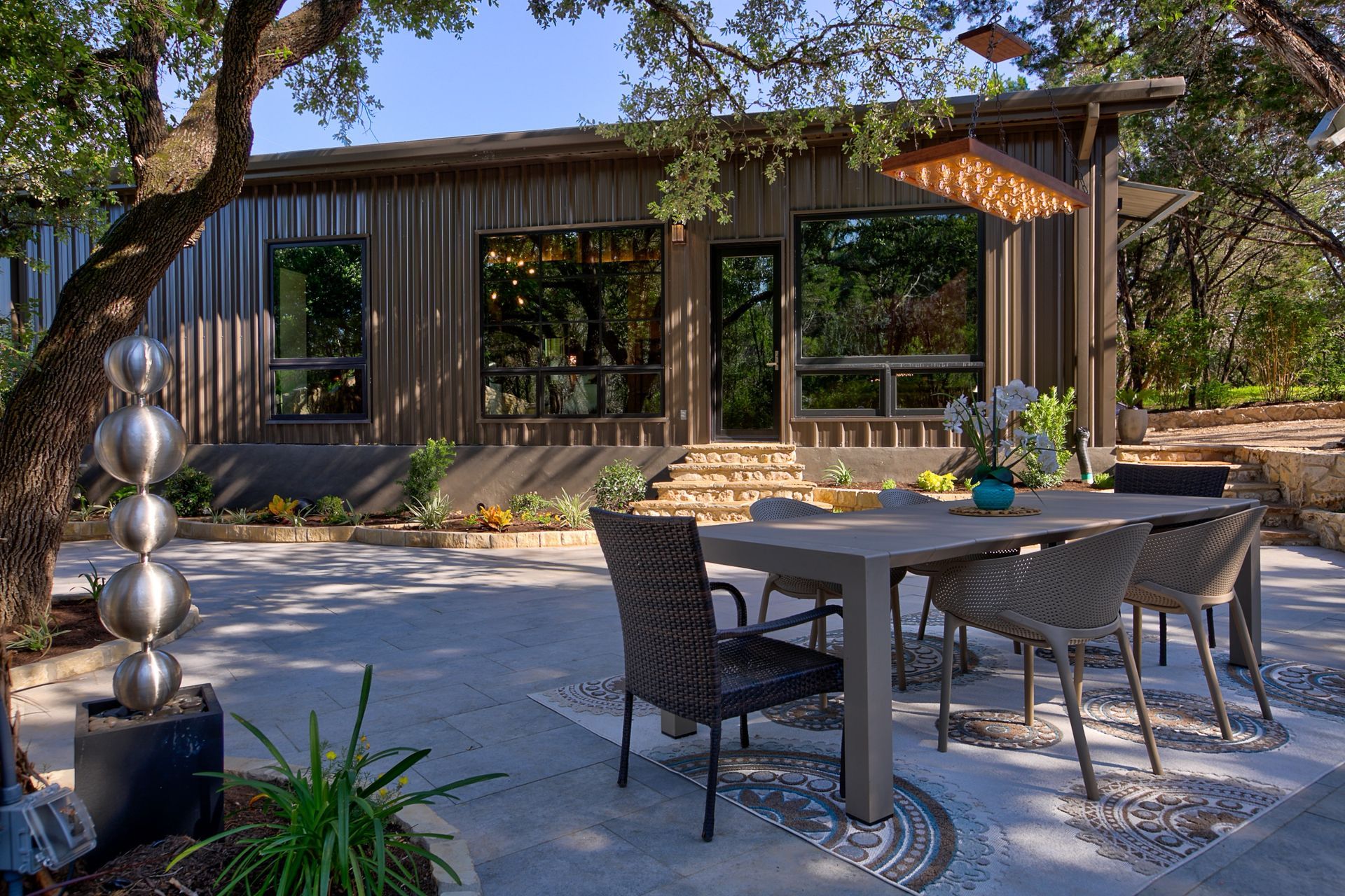 A patio with a table and chairs in front of a house
