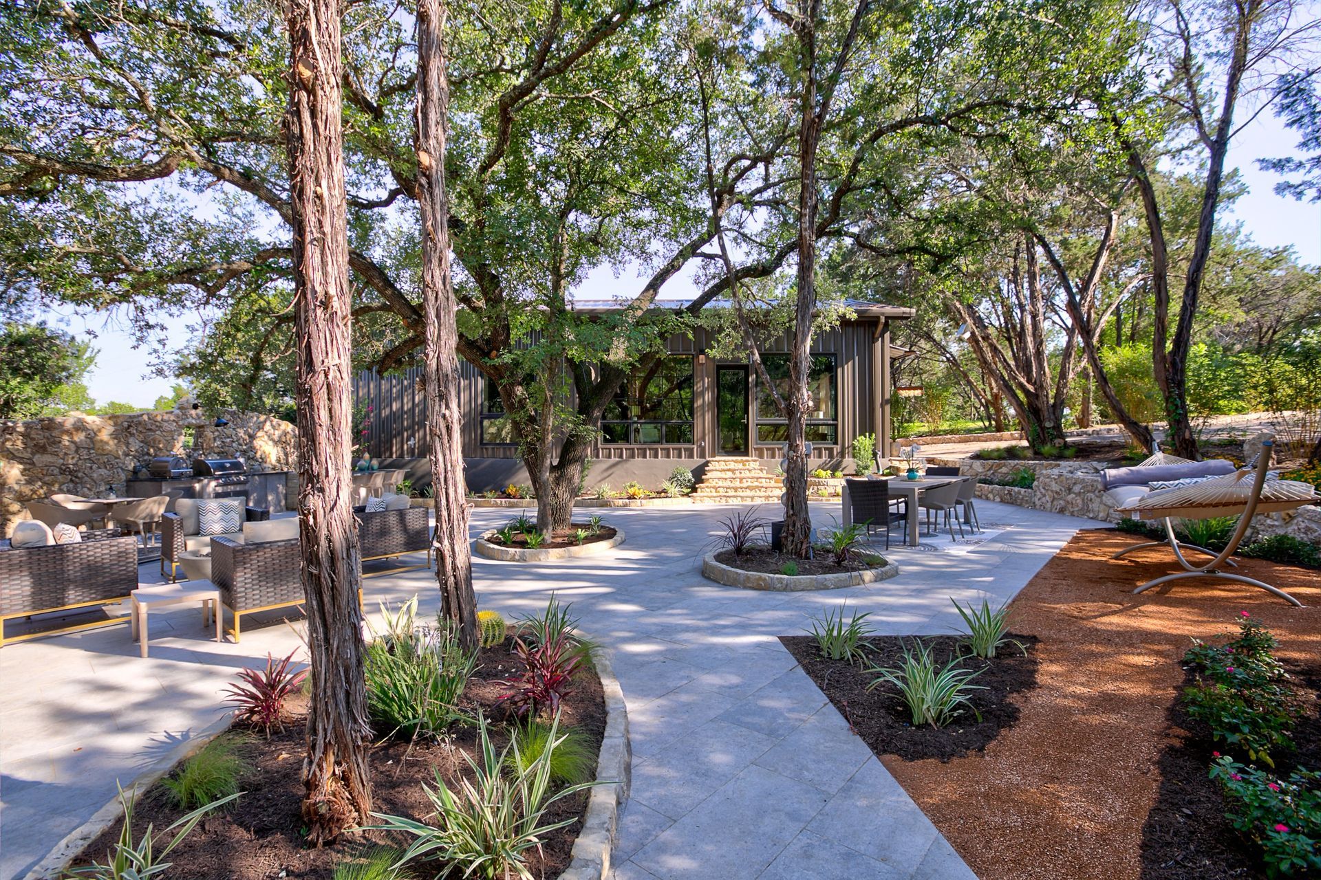 A patio area with trees and a house in the background