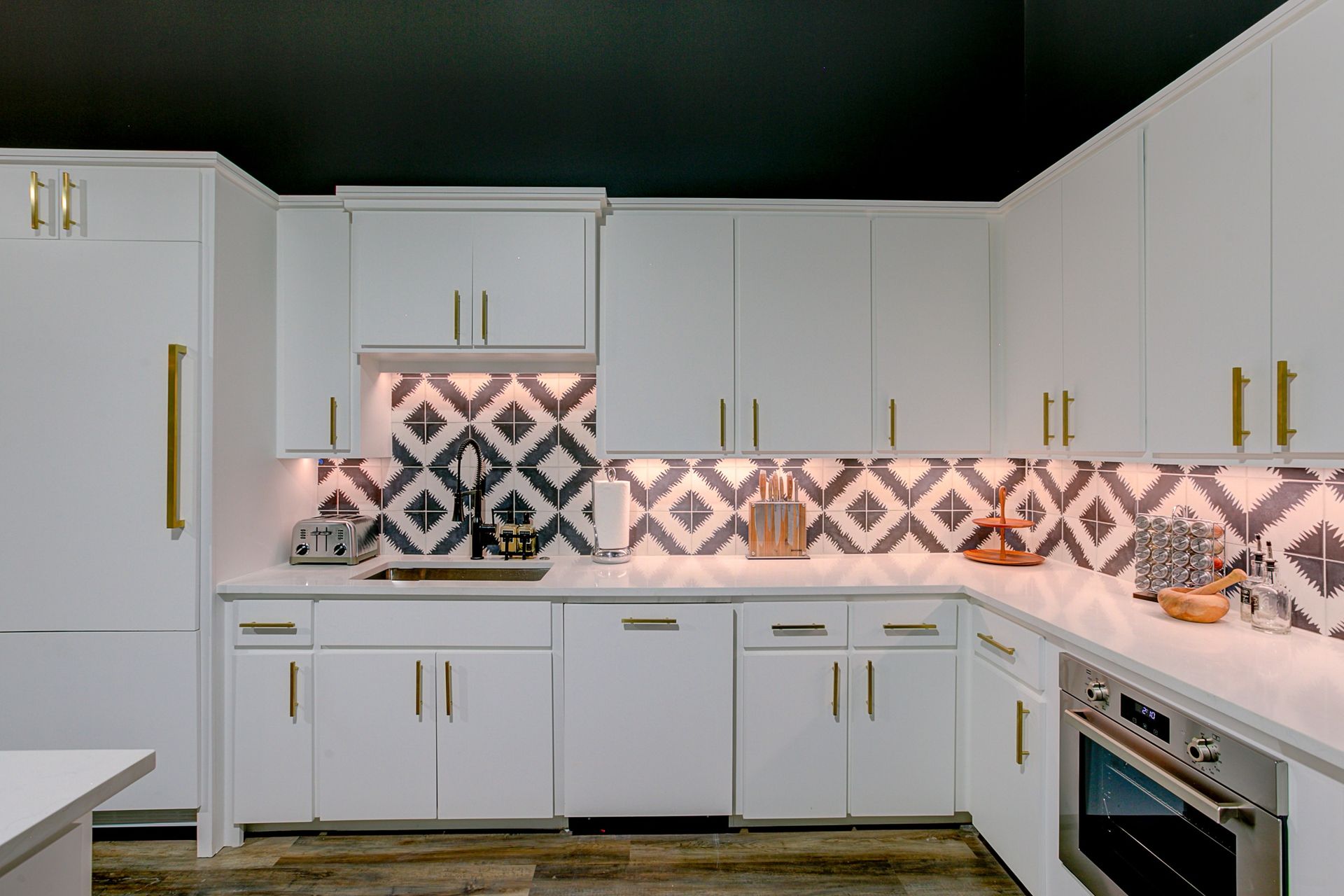 A kitchen with white cabinets and stainless steel appliances