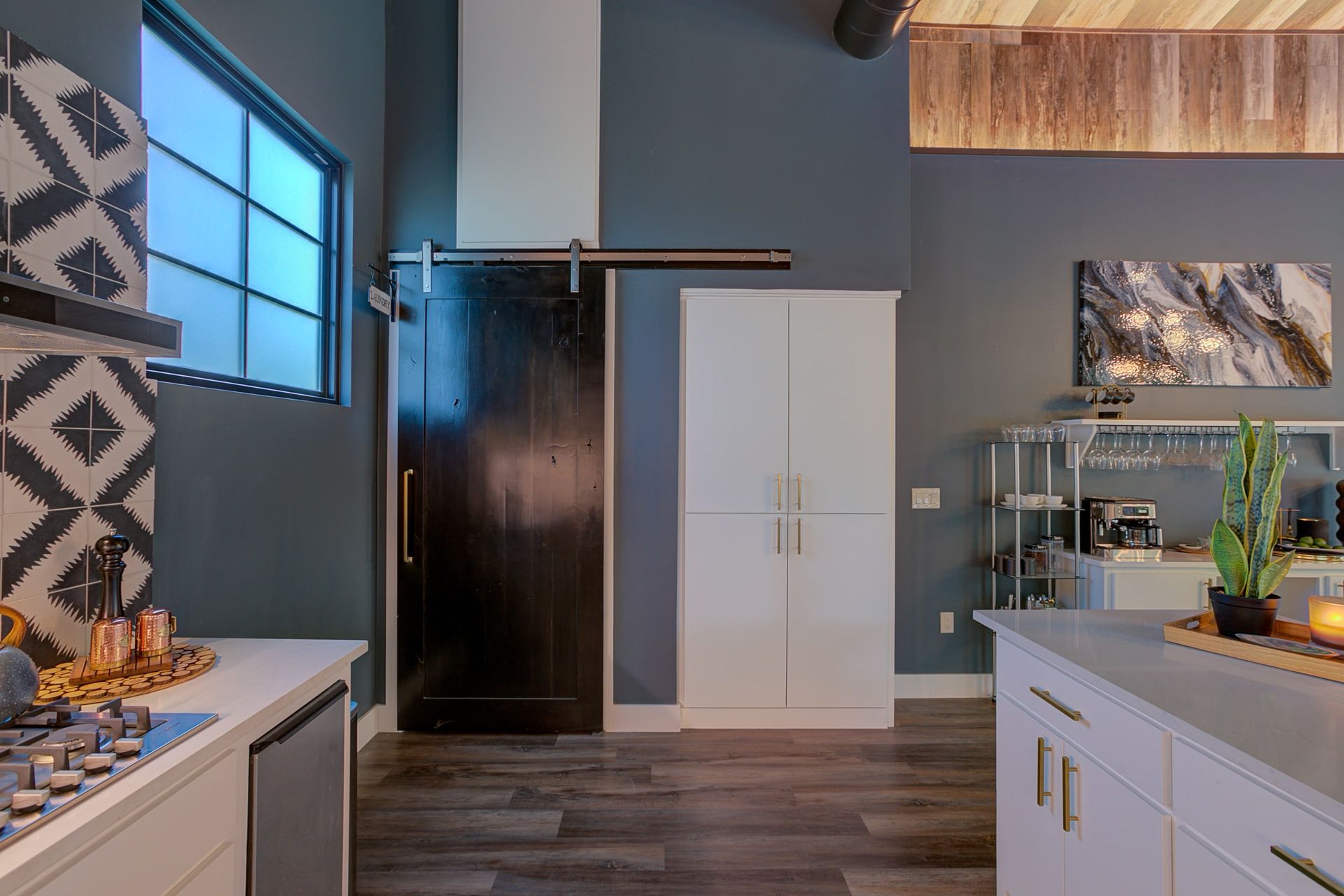 A kitchen with a sliding barn door and a window.