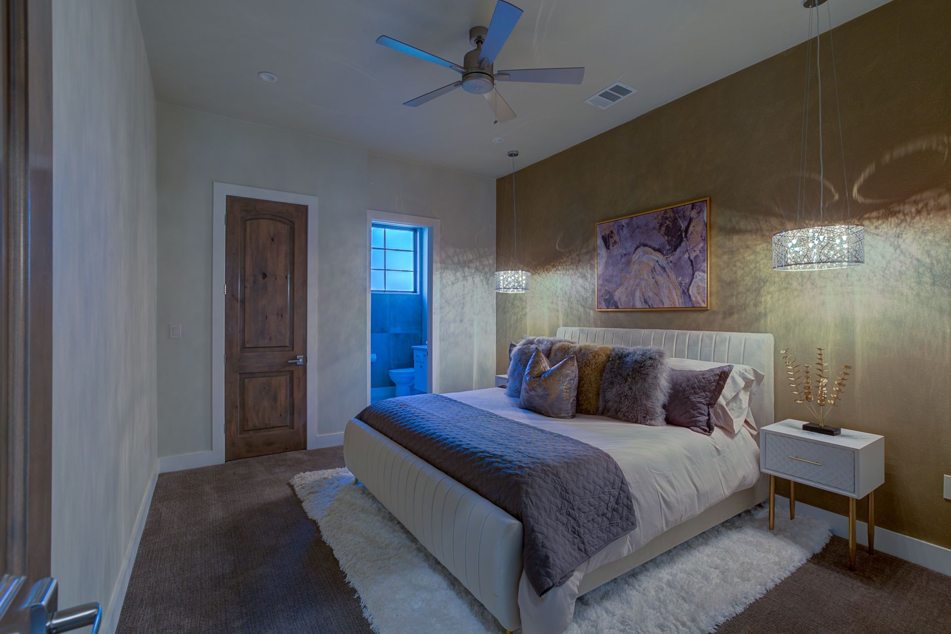 A bedroom with a large bed and a ceiling fan.