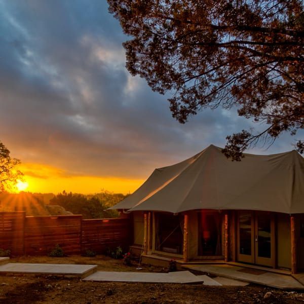 A house with a tent in front of it at sunset