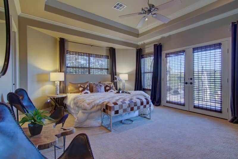 A bedroom with a large bed and a ceiling fan.
