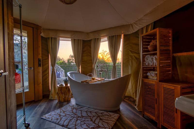 A bathroom with a large tub and a large window.
