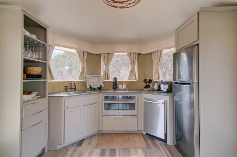 A kitchen with stainless steel appliances and white cabinets.